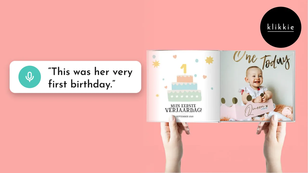 Handen met een open klikkie fotoboek My First Year op de pagina van de eerste verjaardag, met de woorden “This was her very first birthday.”